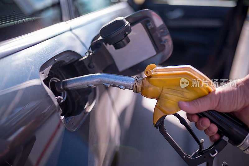 汽车在加油站加油。抽水汽油的人。这张照片可以用于汽车工业或交通概念