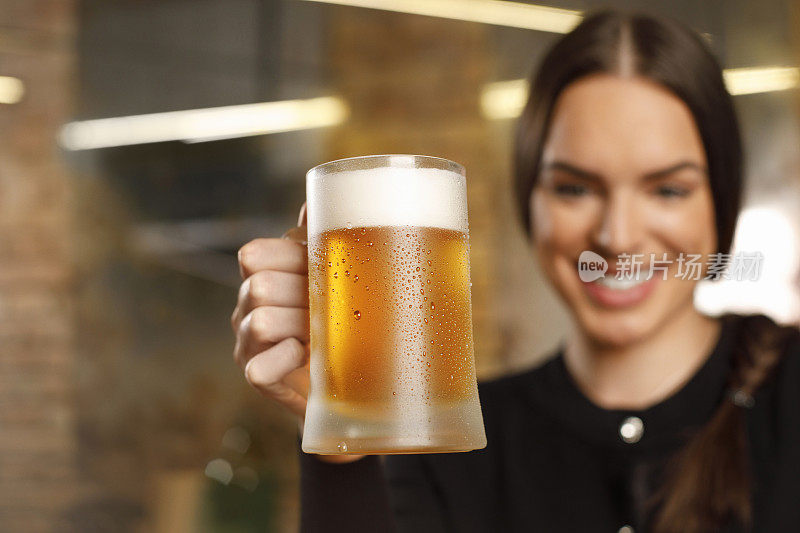 女人喝啤酒冰镇啤酒覆盖着凝结的水珠老复古酒吧的背景
