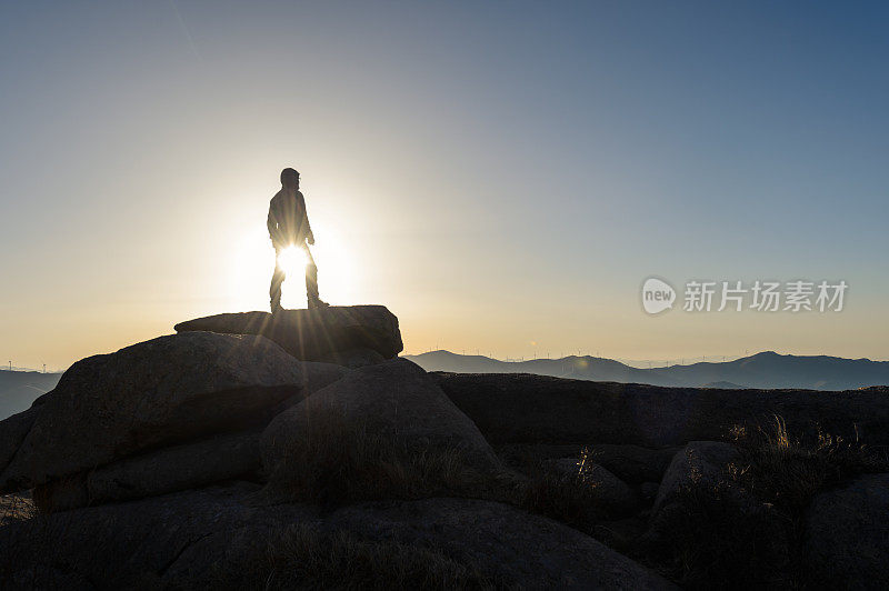 户外游客在日出站的大石头上望出去