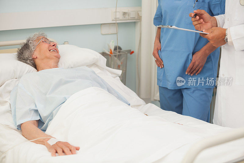 老年女病人微笑着对护士和医生