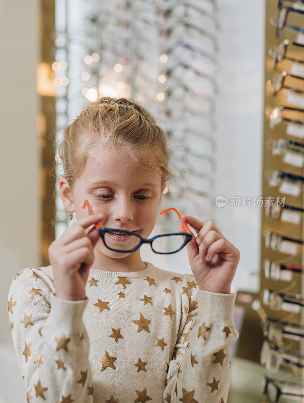 小女孩在眼镜店试新眼镜。