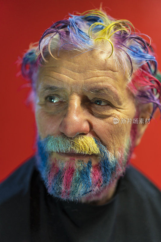 侧视图肖像的高级男子与彩虹色的听到和胡子与红色的背景