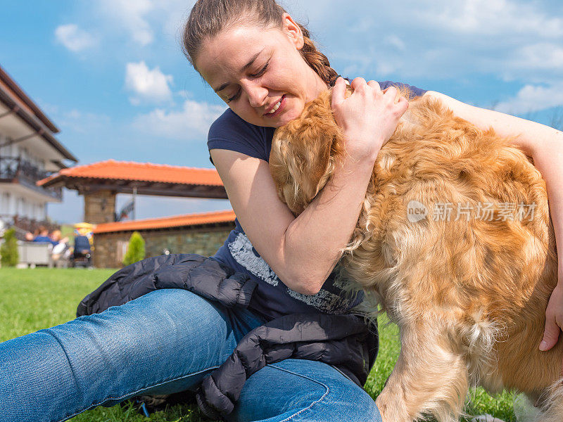 女孩在户外拥抱她的金毛猎犬