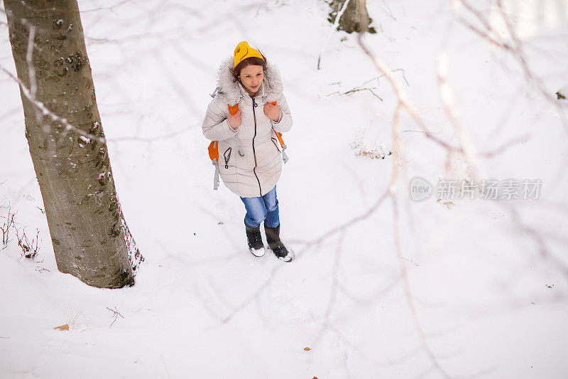 背着背包穿过冬季森林的女人