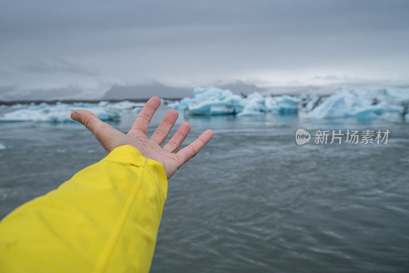 手伸向冰川泻湖冰山