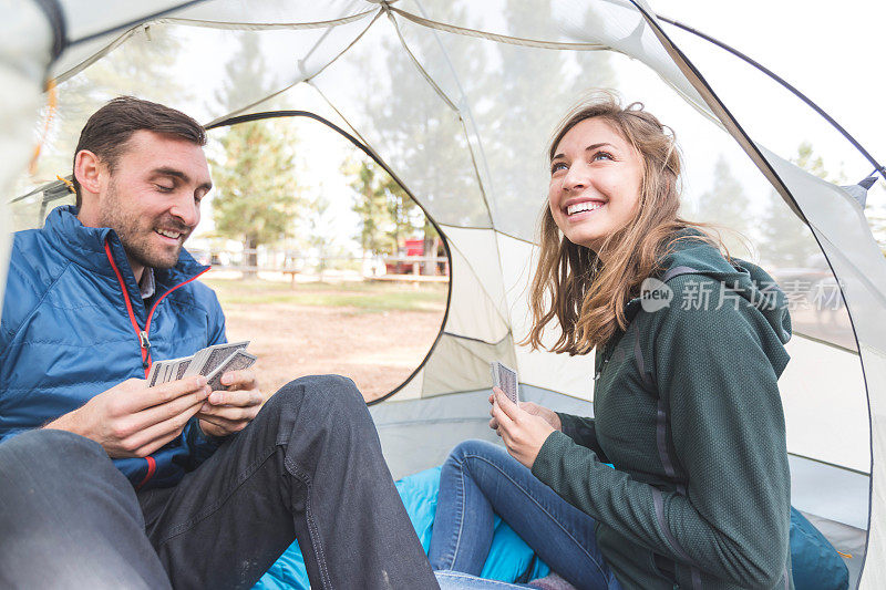 一对千禧一代夫妇在露营旅行中在帐篷里打牌