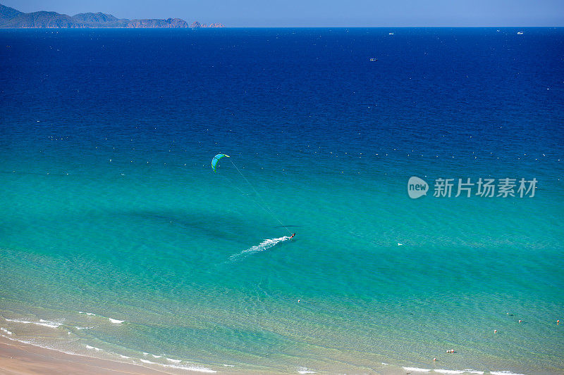 风筝冲浪在热带碧水海滩上从空中鸟瞰拍摄的照片