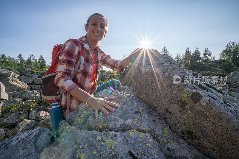 女攀登者攀登山顶;湖景