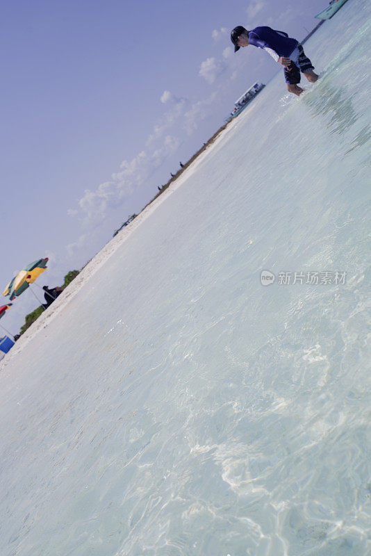 在马尔代夫马夫什岛附近的沙滩上，孩子们沿着斜线上下走下水山