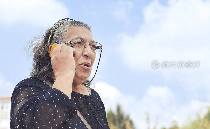 正在用手机聊天的资深女性