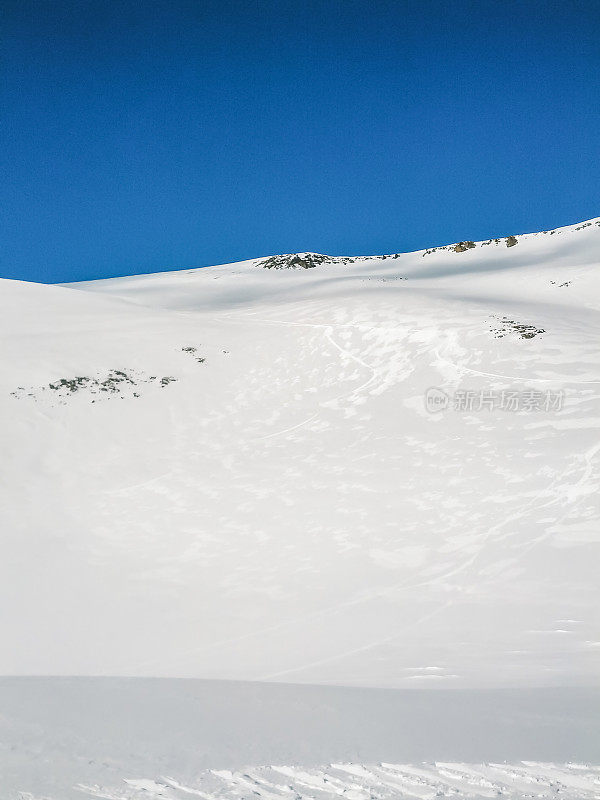 垂直拍摄的冰岛蓝天下覆盖着积雪的土地