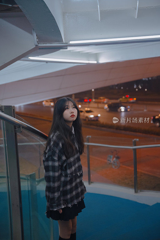 孤独的亚洲女孩在夜晚的桥上
