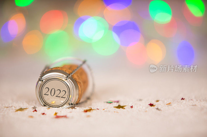 2022年新年快乐，星星形状和软木在雪地上