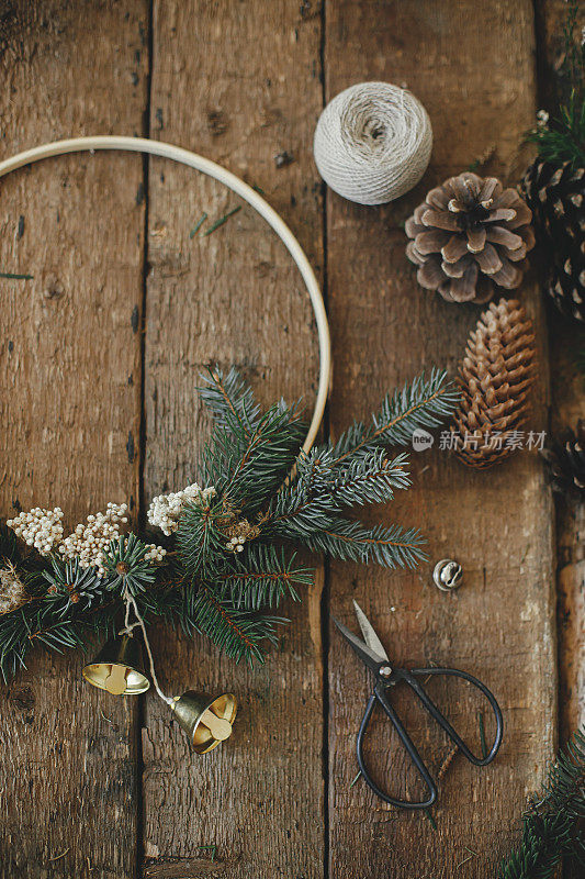 现代的圣诞花环，质朴的平铺。最小的花环有铃铛，冷杉，松果，剪刀