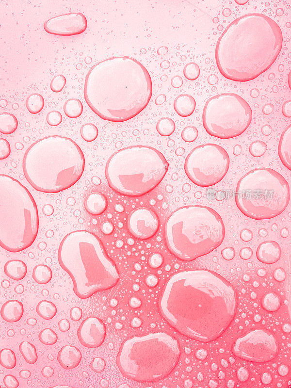 在粉红色的表面上的液滴的特写