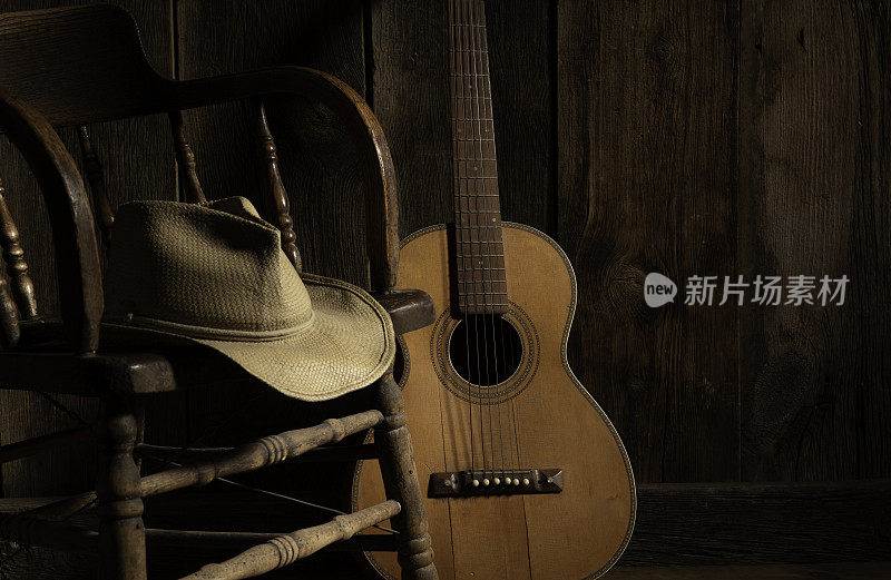 谷仓木材背景与椅子，吉他和牛仔帽