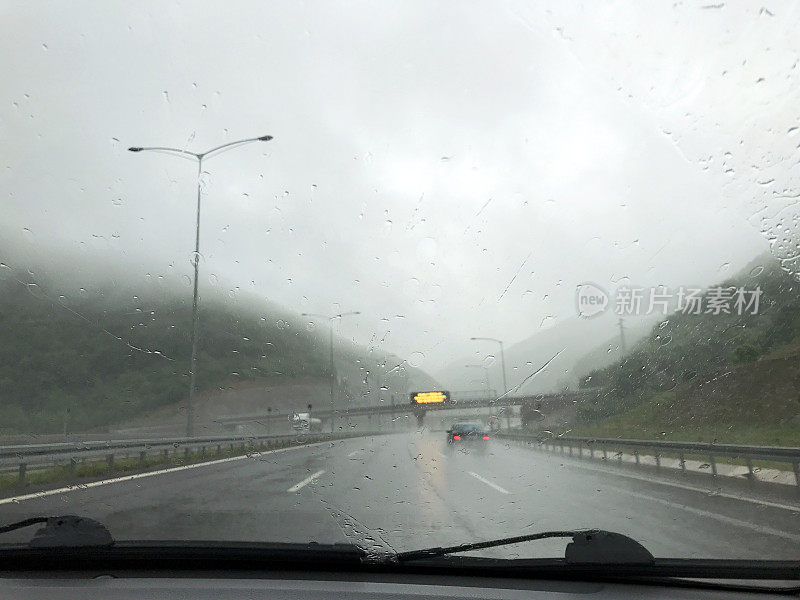 专注于车流中落在车窗上的雨滴