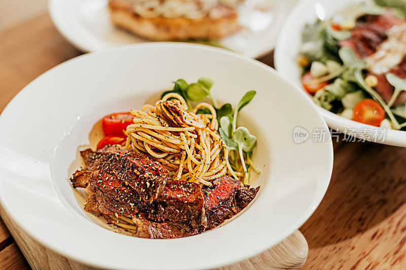 意大利面与牛肉，番茄，蔬菜精致的餐盘食物造型高分辨率股票照片