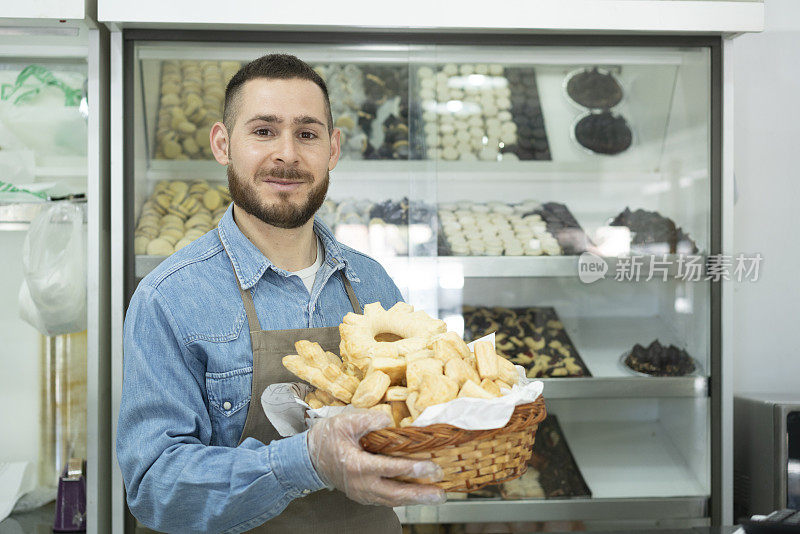 面包店男员工的肖像，手里拿着篮子，里面放着咸味糕点