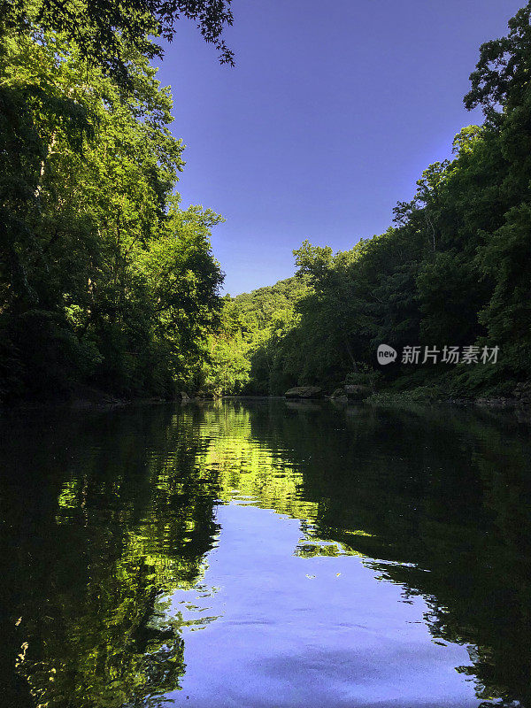 碧蓝的河水缓缓流下，绿树和蓝天环抱着这条河