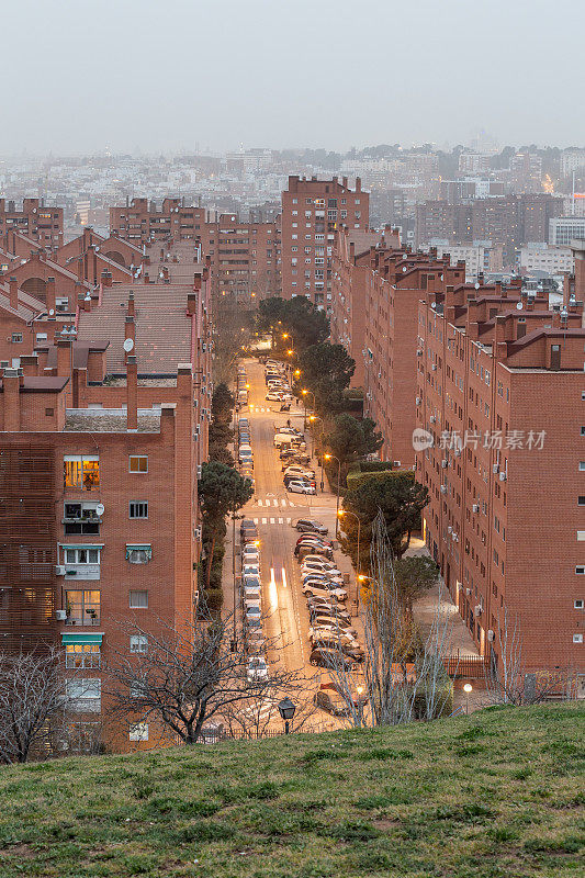 郊区街道的黄昏，以马德里市为背景，笼罩在雾霾和污染的大气中
