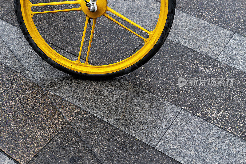 黄色自行车停在雨地上