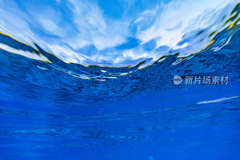 抽象的海洋表面从水下仰望湛蓝的天空