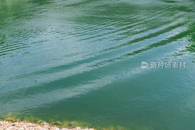 湖面上荡漾着涟漪，湖水墨绿色，波浪起伏