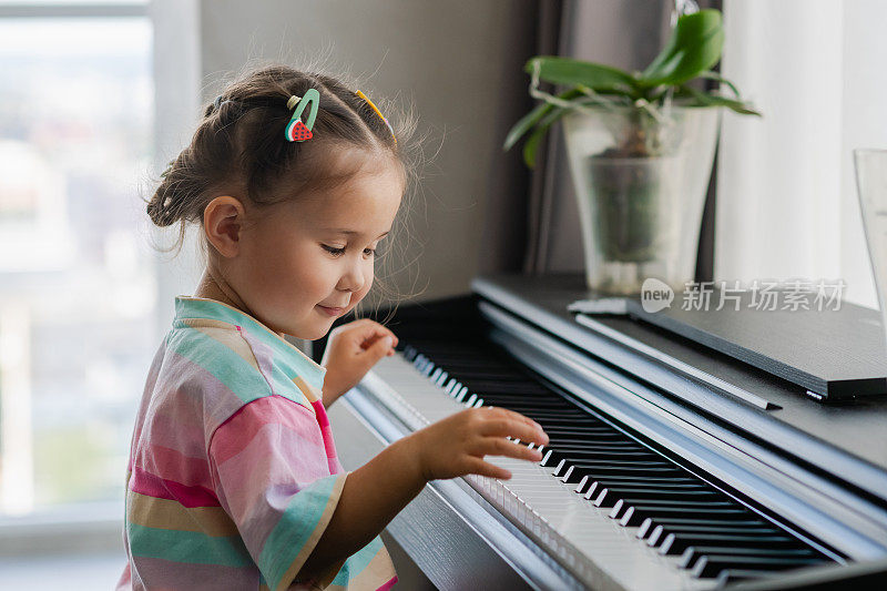 可爱的小女孩在音乐学校弹钢琴。