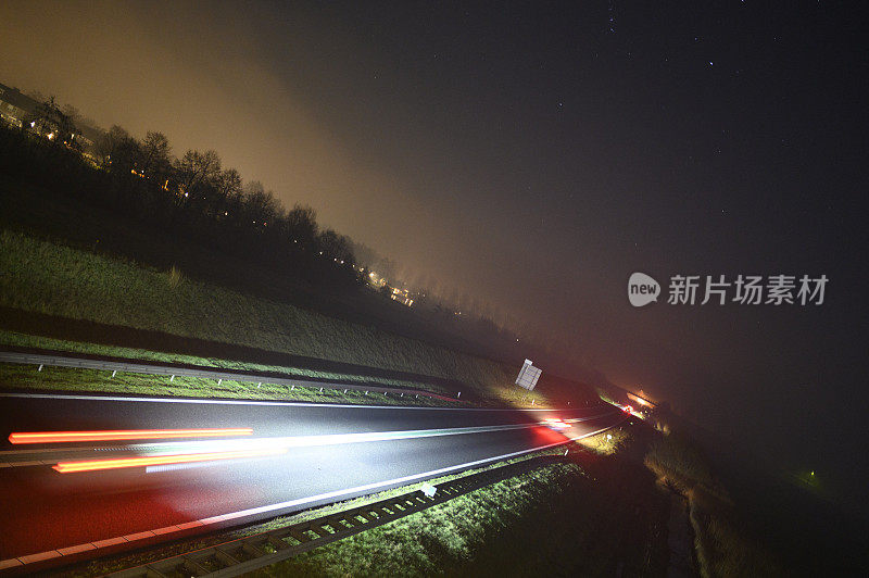 在冬天有雾的黑夜中行驶在道路上的车辆