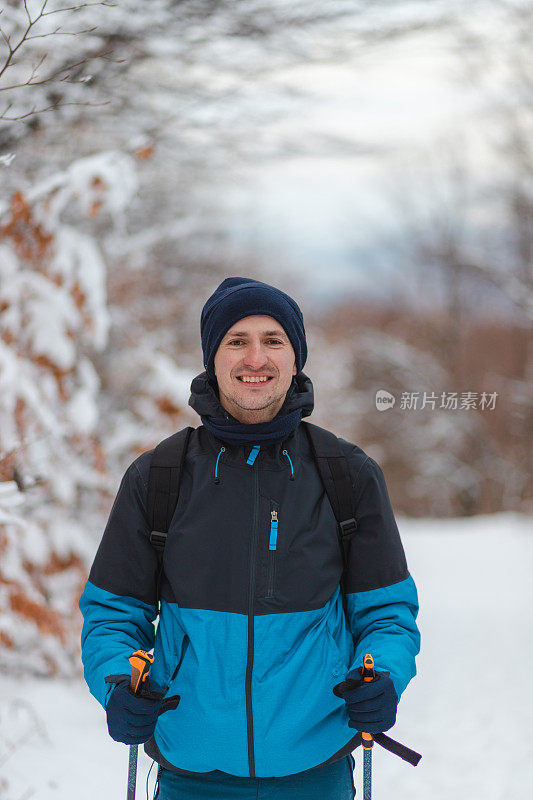 一个年轻英俊的男子徒步旅行者在山顶的腰肖像