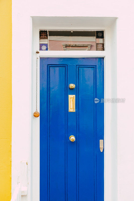 城市街道上的住宅蓝色前门和黄色立面