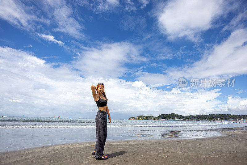 站在夏日沙滩上的女子全身画像