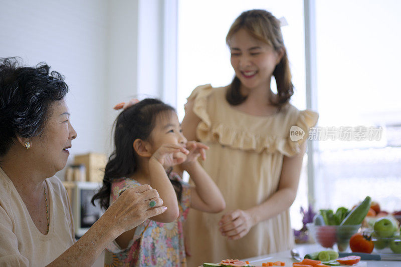 奶奶、妈妈和孙女在厨房准备食物。