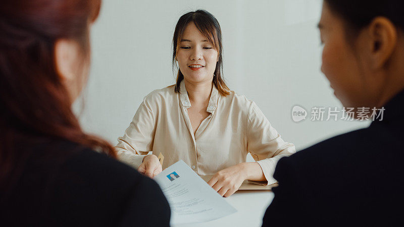 年轻的亚洲女性通过面试，坐在办公室的人力资源经理面前。人力资源，招聘机构。