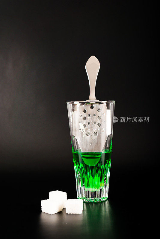 一种叫苦艾酒的绿色伏特加，装在小玻璃杯里，用特制的勺子和白糖块盛着