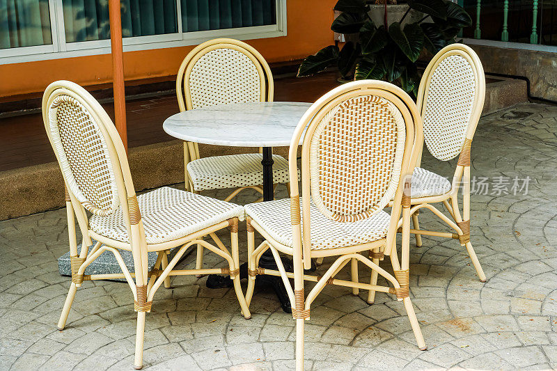 泰国，一张白色塑料餐桌，可放置在阳台、花园或建筑物前。