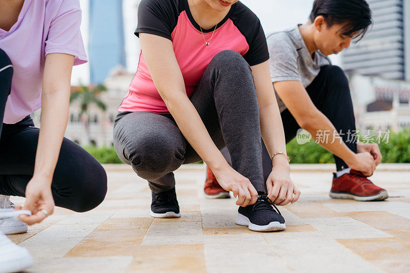 年轻的亚洲男人和女人系鞋带