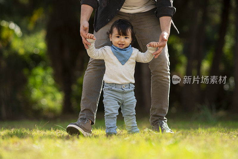 爸爸在后院帮小男孩练习走路