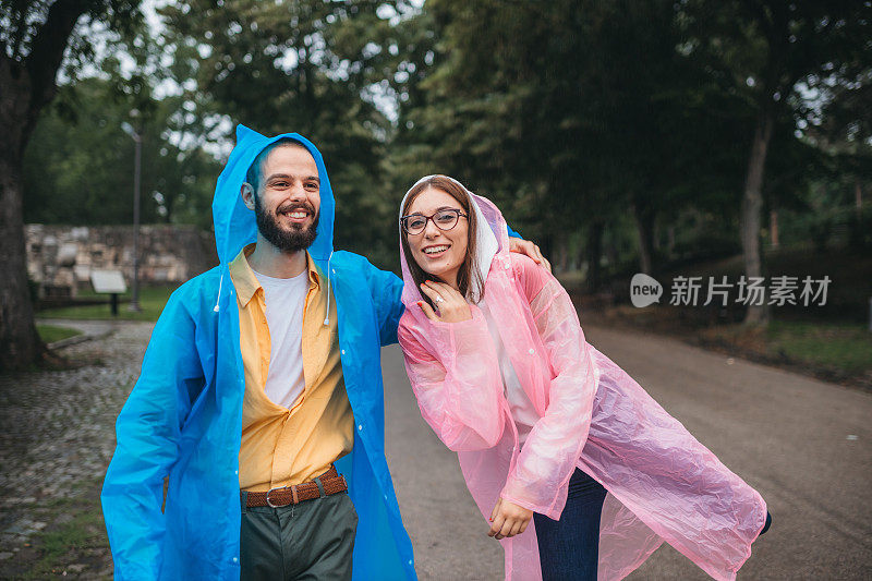 这是一对穿着雨衣在雨中徒步旅行的情侣