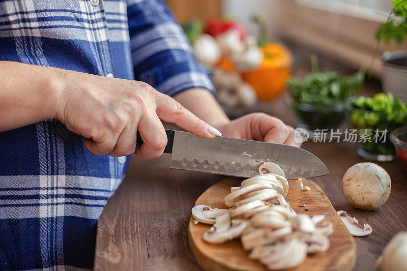 年轻女子在家切蘑菇做披萨