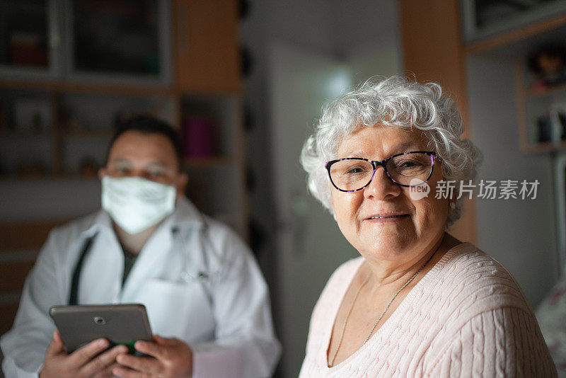 病人-老年妇女和健康访视员在家访期间的肖像