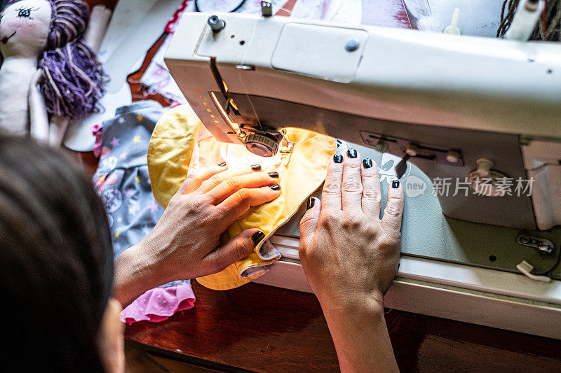 俯视图女性的手缝制衣服自制娃娃