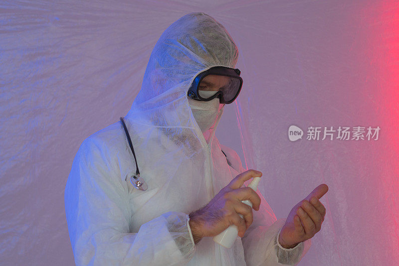 身穿防护服、戴面罩的医生正在手部消毒，以防冠状病毒感染。