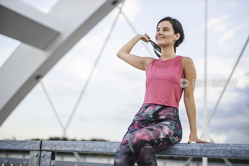 快乐的运动女人在户外慢跑后休息