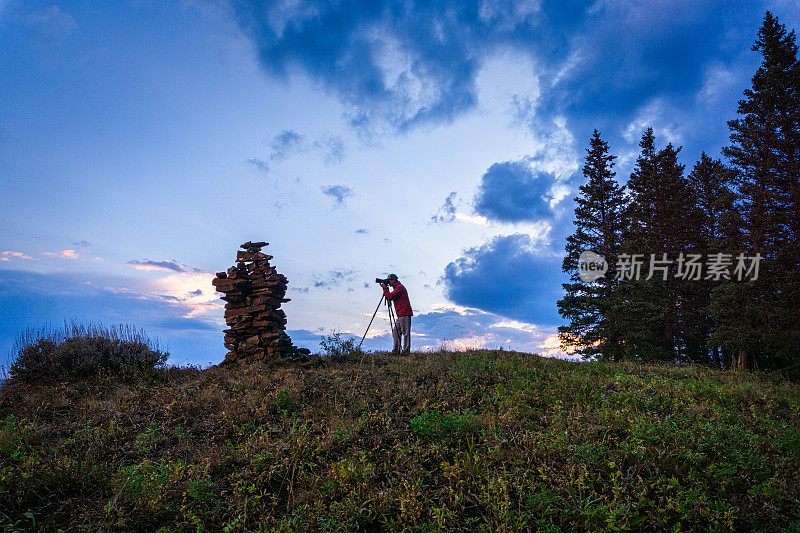 摄影师在山脊上捕捉戏剧性的日落景观