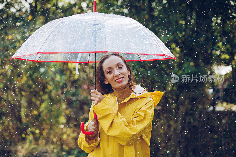 快乐的女人在雨中行走