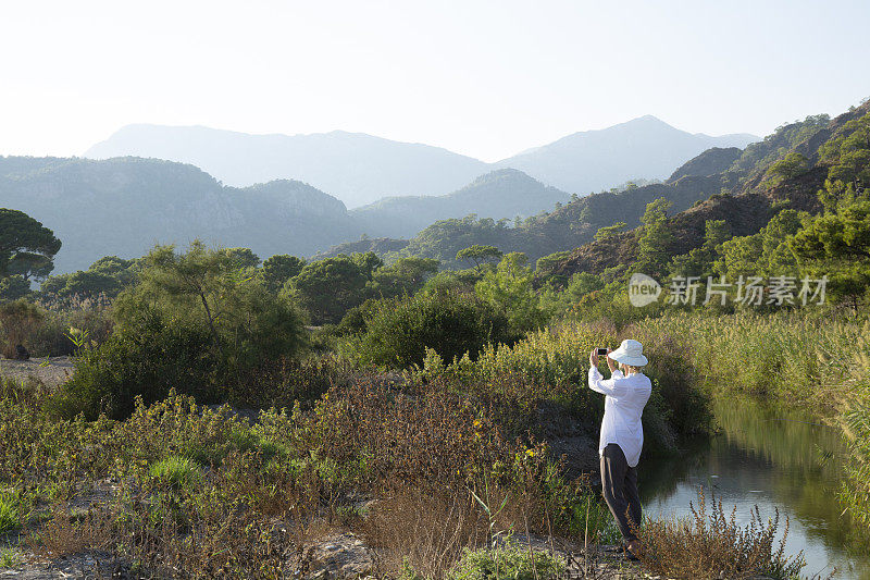 清晨，女性徒步旅行者在茂密的森林里放松