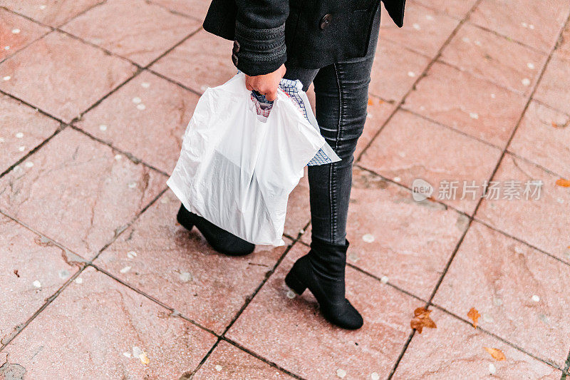 拿着塑料袋走路的女人