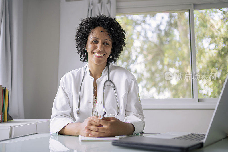 黑人女医生使用笔记本电脑进行远程医疗视频通话的肖像。